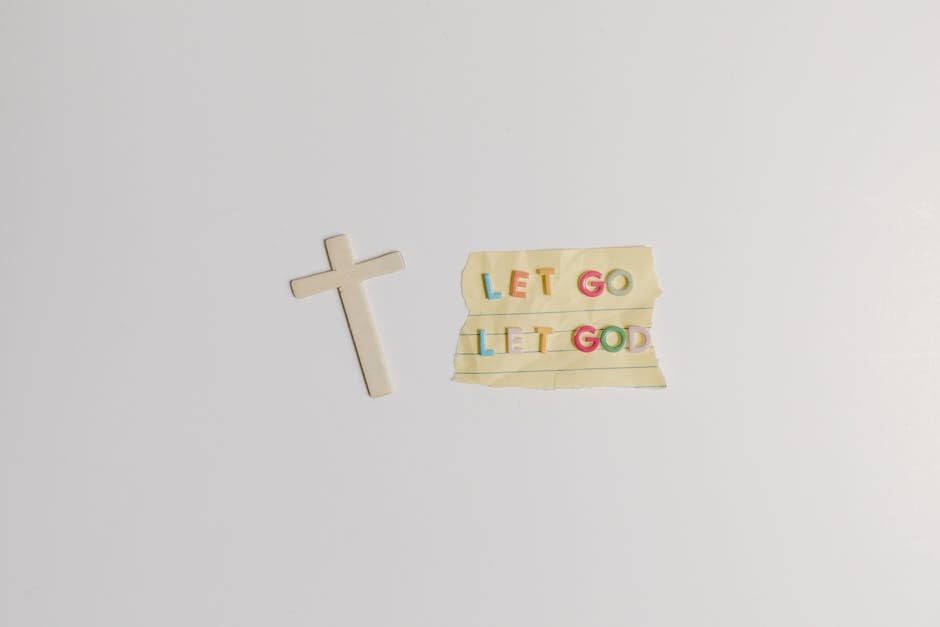 A simple and powerful image featuring a cross alongside the inspiring quote 'Let Go Let God' on paper.