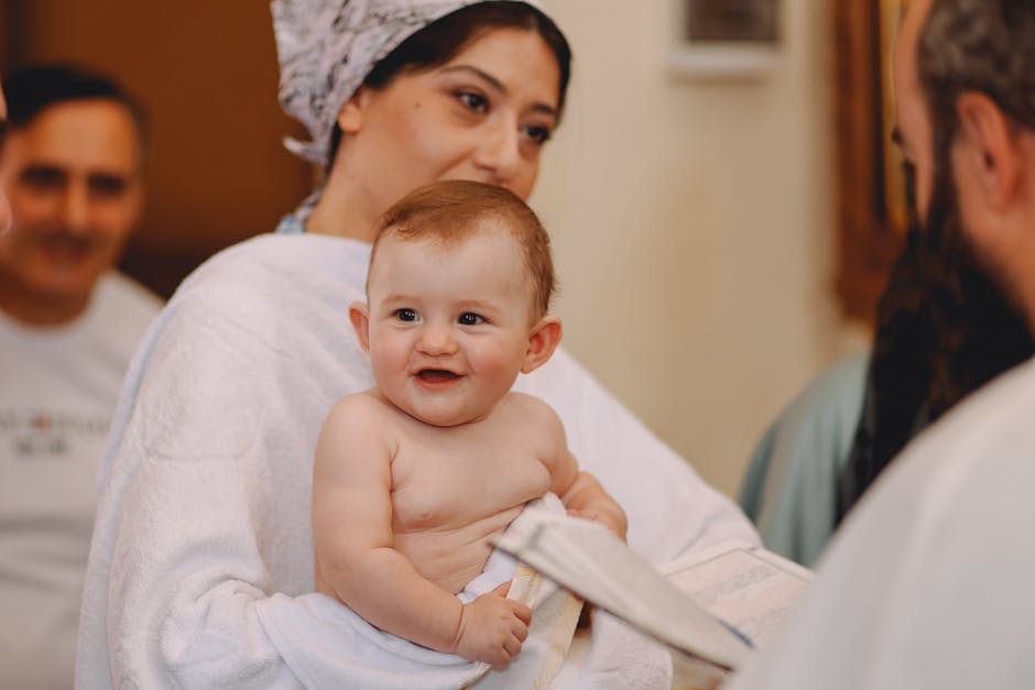 Adorable baby held by a mother during a baptism ceremony in a church setting.