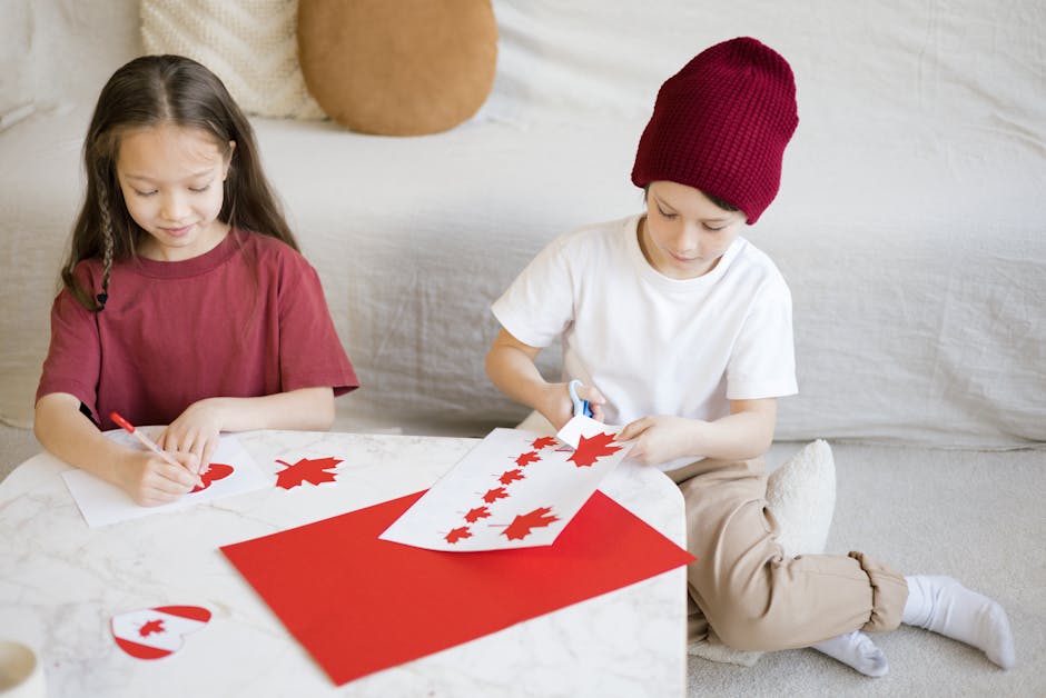 Two children engage in crafting Canadian flags indoors to celebrate Canada Day.