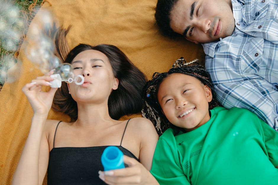A joyful family scene with parents and daughter enjoying the outdoors and blowing bubbles.