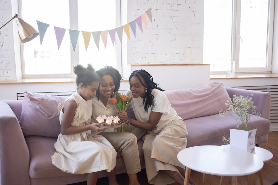 A joyful moment of family bonding with cupcakes and flowers on the sofa.