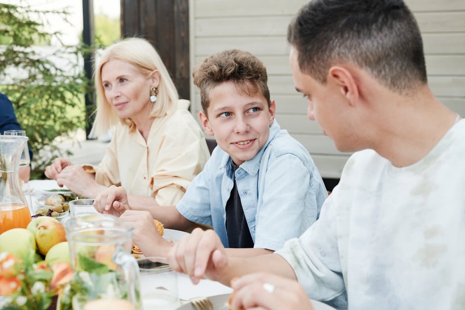 A family gathering outdoors sharing a meal, engaging in lively conversation.