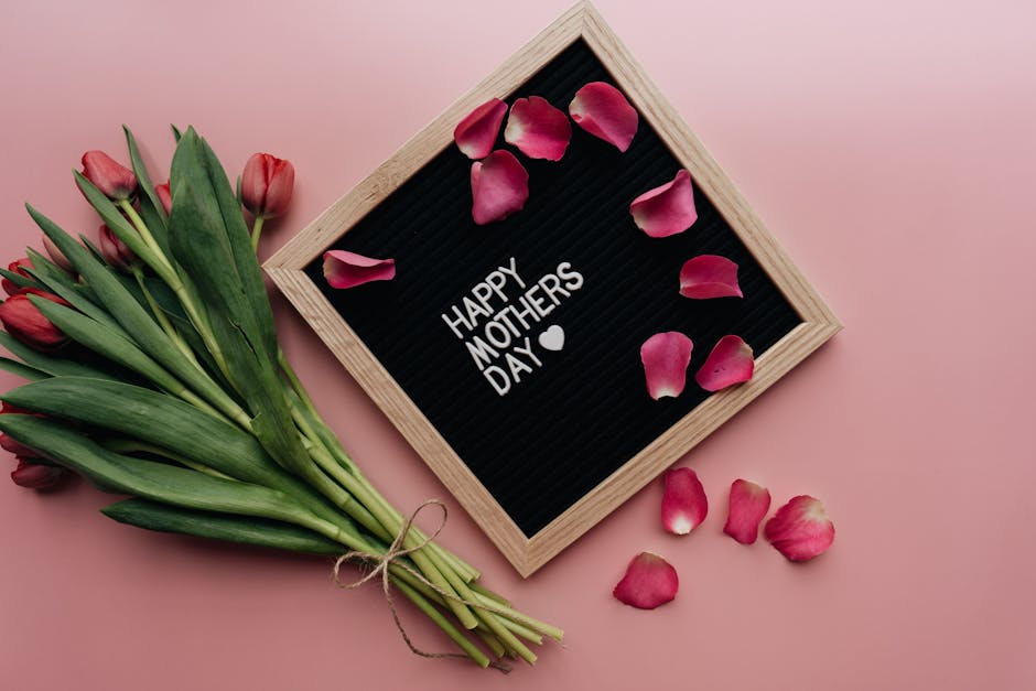 Beautiful Mother's Day arrangement with tulips and letterboard on pink background.