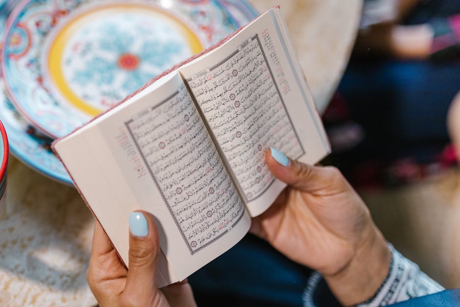 A woman engrossed in reading the Quran, signifying devotion and faith.