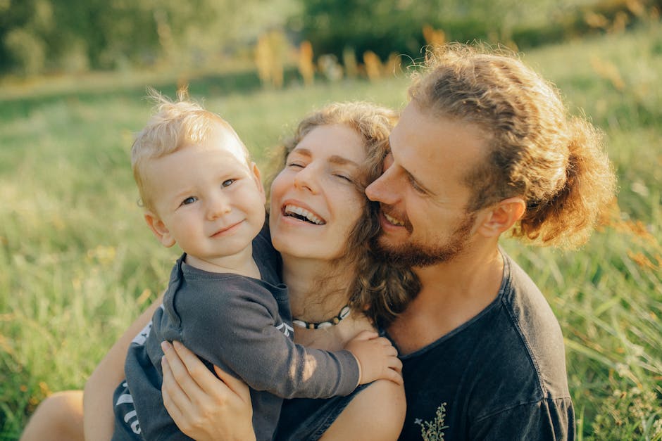A joyful family moment captured in a sunny meadow, portraying love and togetherness.
