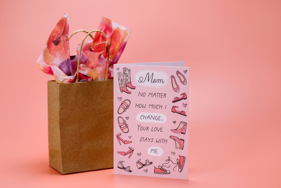 Mother's Day card with heartfelt message and gift bag on pink surface.