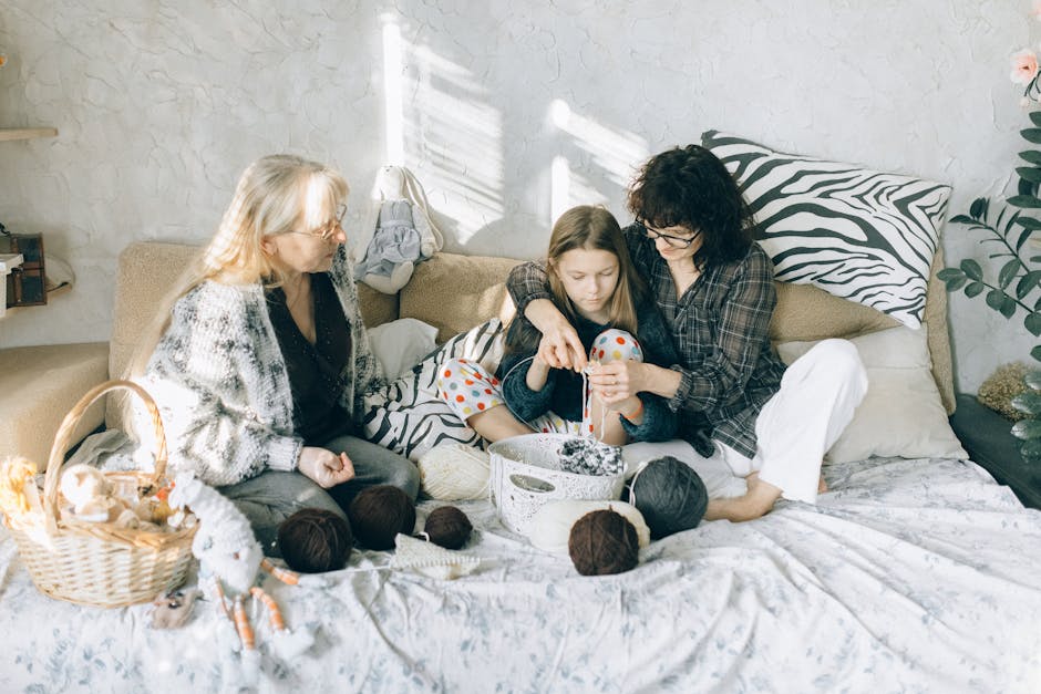 Grandmother, mother, and daughter enjoying knitting together at home. A warm family bonding moment.