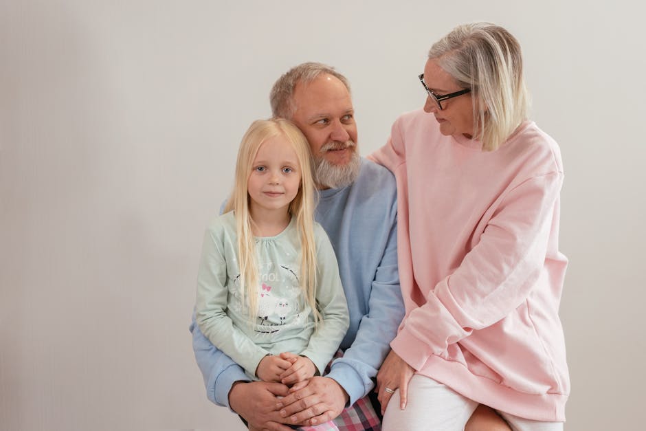 Grandparents lovingly embrace their granddaughter in a bright, studio setting, capturing family warmth and connection.