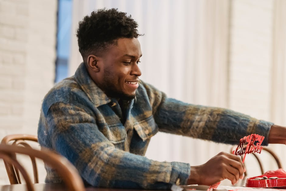 Smiling man arranging Valentine's Day decorations at home.