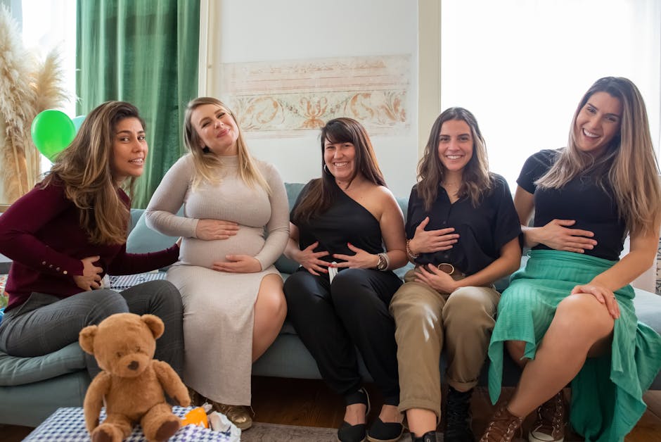 Happy group of women celebrating a baby shower, sitting on a couch with smiles and joy.