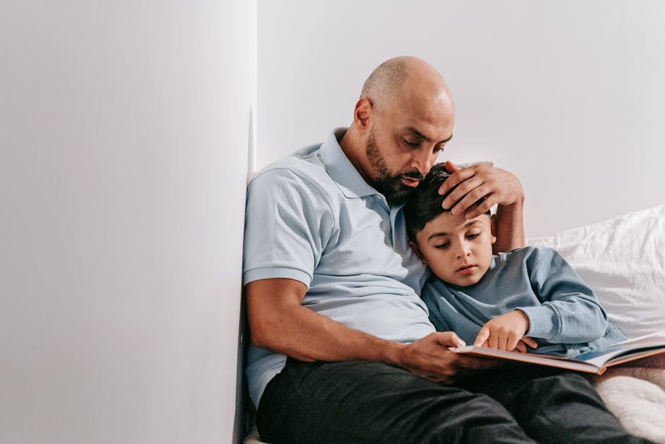 Father and son bonding while reading a book indoors, capturing a moment of family connection.