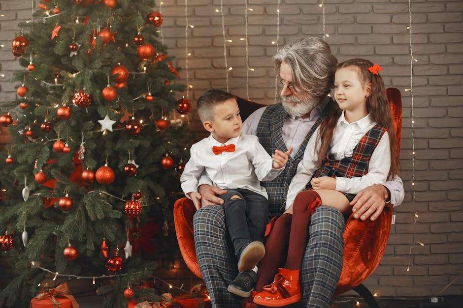 Grandfather with grandchildren celebrating Christmas by the decorated tree indoors.