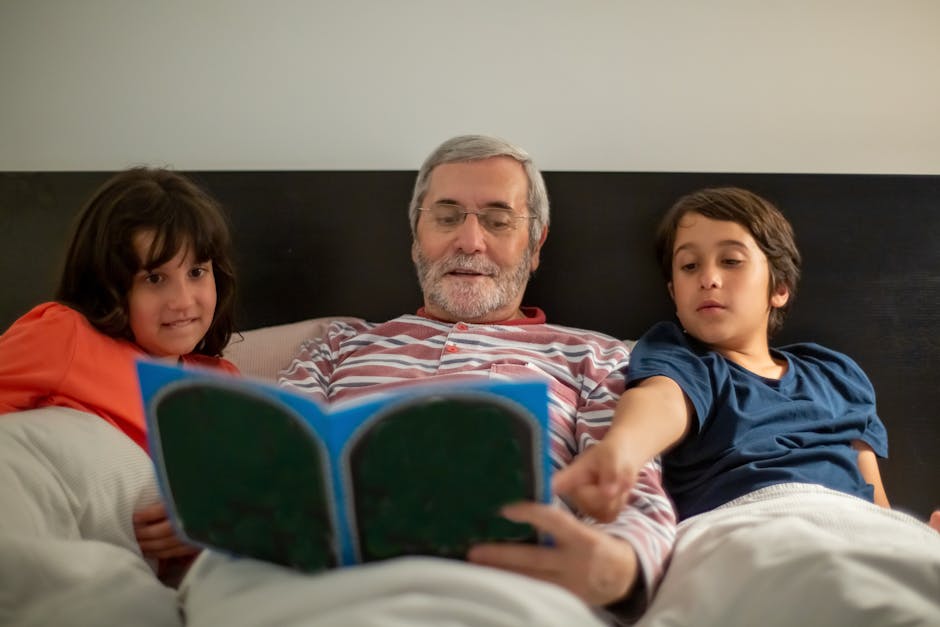 Grandfather reading a book in bed with his grandchildren, creating a cozy family moment.