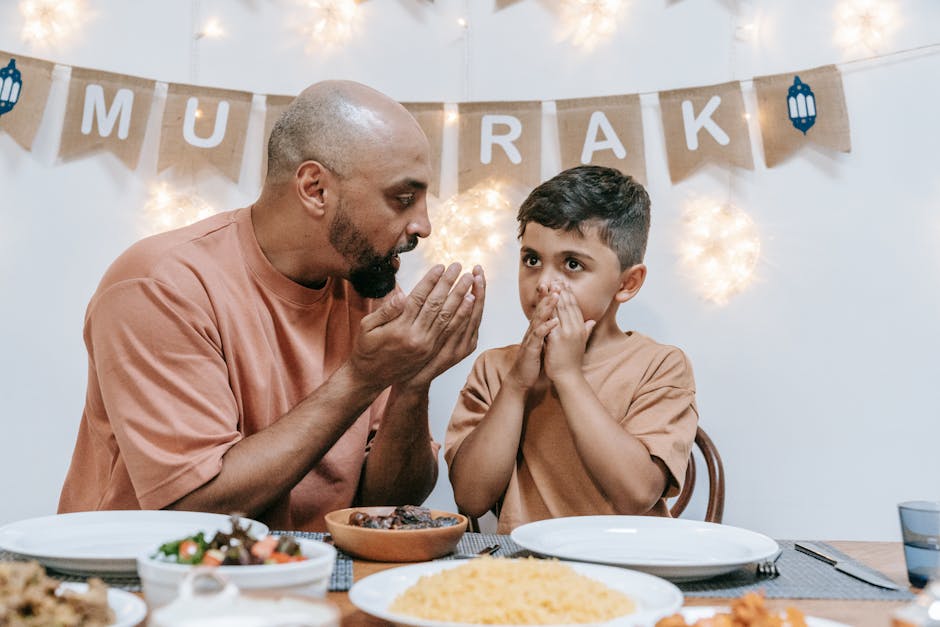 Father and son in prayer before enjoying an Eid meal together at home.