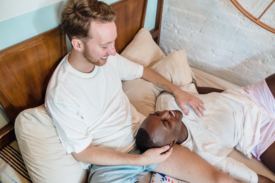 A joyful couple sharing a tender moment in bed, showcasing love and happiness.
