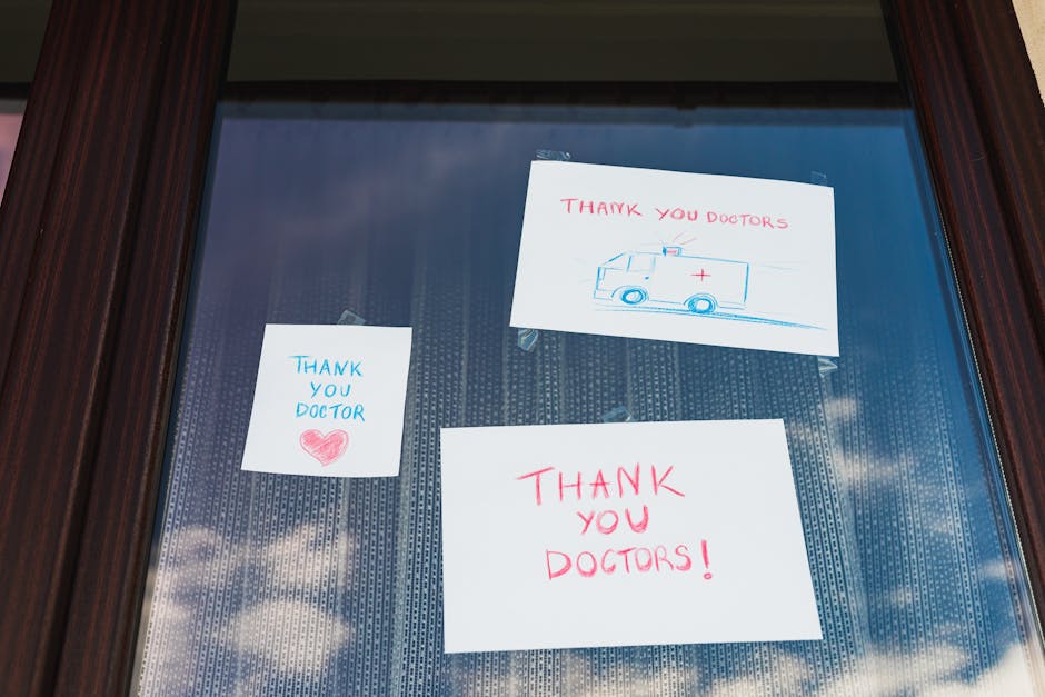 Handwritten notes on a window expressing gratitude towards doctors, featuring colorful drawings.