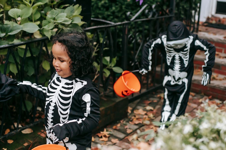 Two children dressed as skeletons walk with Halloween buckets, enjoying trick-or-treat festivities outdoors.