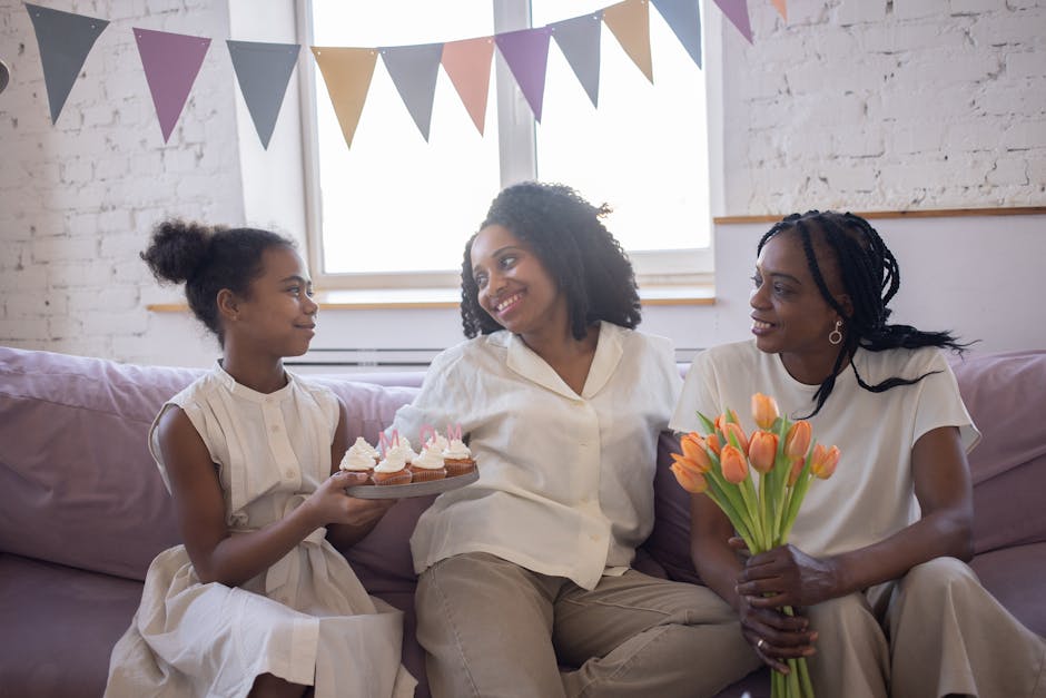 Mother and daughter celebrating with cupcakes and tulips indoors.