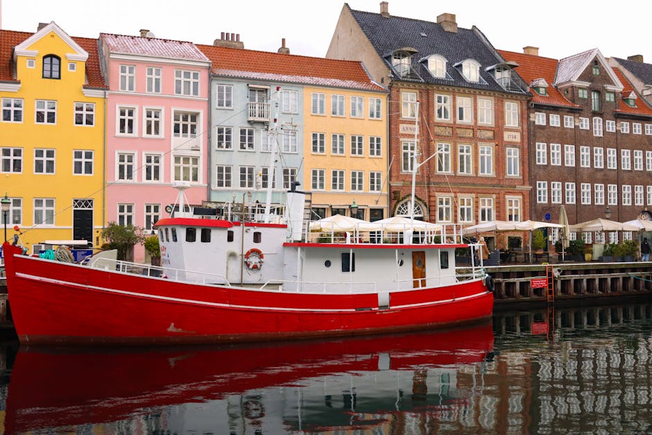 Vibrant buildings and red boat in Nyhavn Canal, Copenhagen, Denmark.