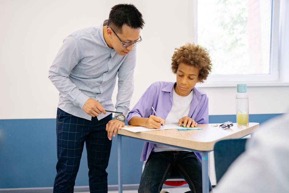 Teacher helps a student with schoolwork in a modern classroom environment.