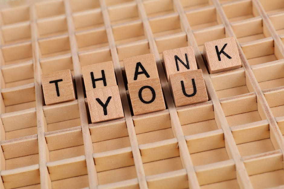 Creative arrangement of wooden blocks spelling 'Thank You' on a wooden surface.