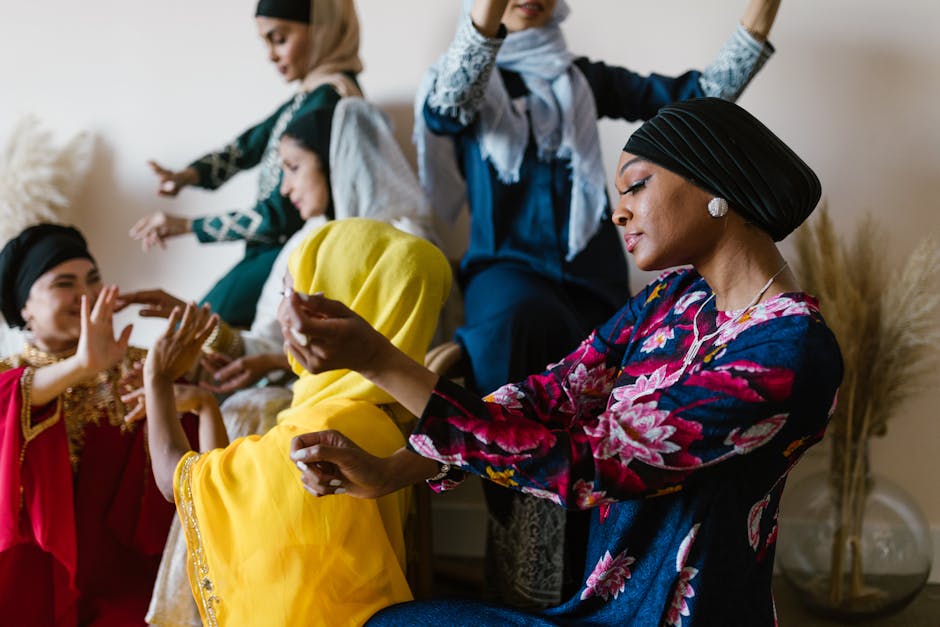 A vibrant group of women in colorful traditional attire celebrating indoors, expressing joyful movements.