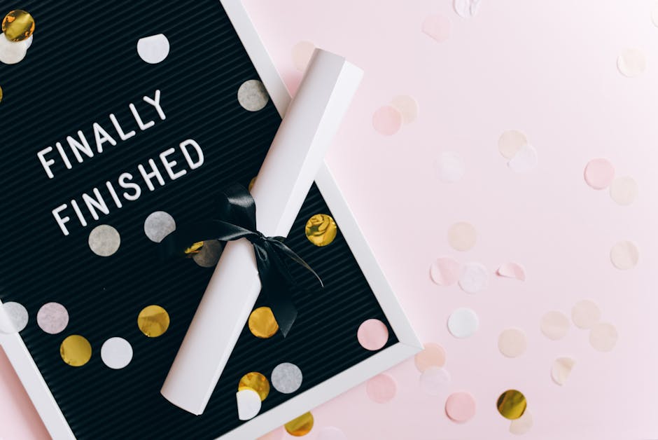 A graduation scene with a diploma and confetti on a letter board reading 'Finally Finished.'