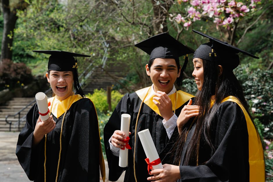 Group of diverse students celebrating graduation with diplomas outdoors.
