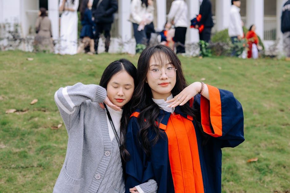 Two friends celebrating a graduation outdoors. Cheerful and relaxed atmosphere.
