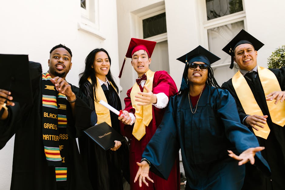 Joyful graduates in academic gowns celebrate their achievement outdoors.