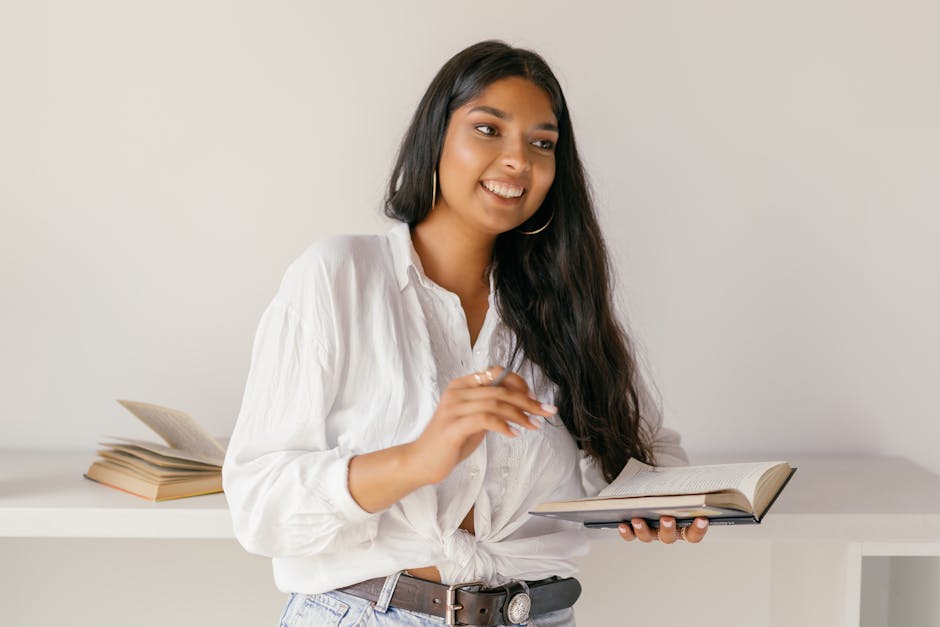 Cheerful teenage student holding a book, focusing on education and learning.