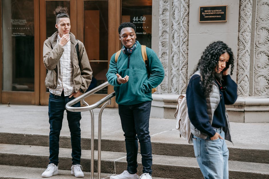 A group of diverse students socializing outside a university building, showcasing modern youth lifestyle.