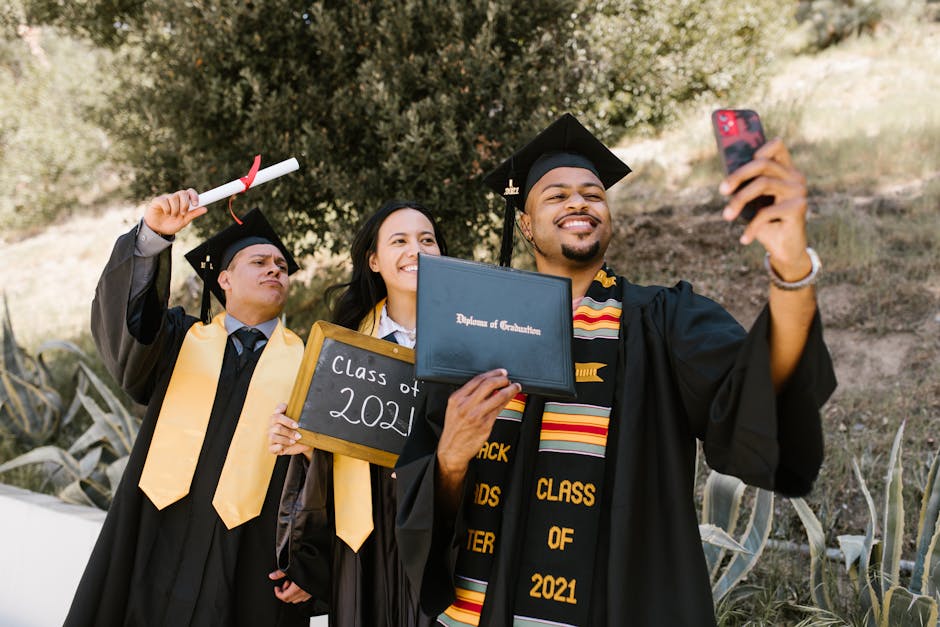 A joyful graduation moment captured with friends taking a selfie, holding diplomas, and celebrating together.