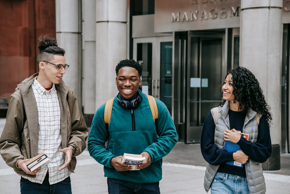 Happy students walking and talking outside an academic building, embracing diversity and friendship.