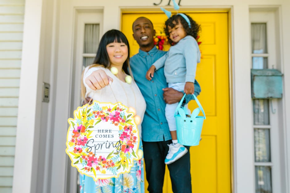 A joyful family welcomes spring with floral decorations and smiles at their yellow front door.