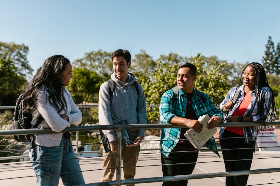 A diverse group of happy college students socializing on a sunny day outdoors.