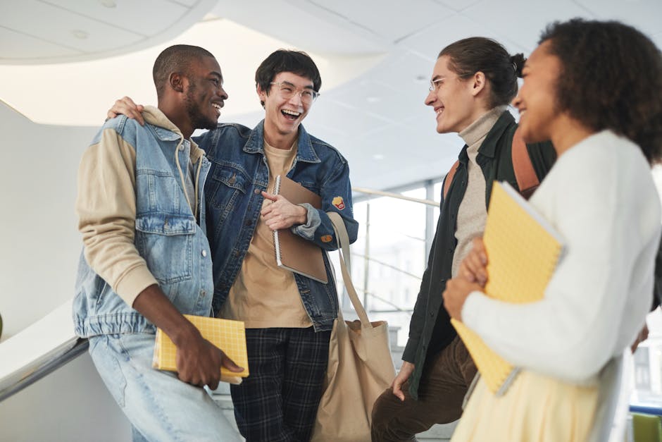 A diverse group of young adults laughing and socializing inside a modern building.