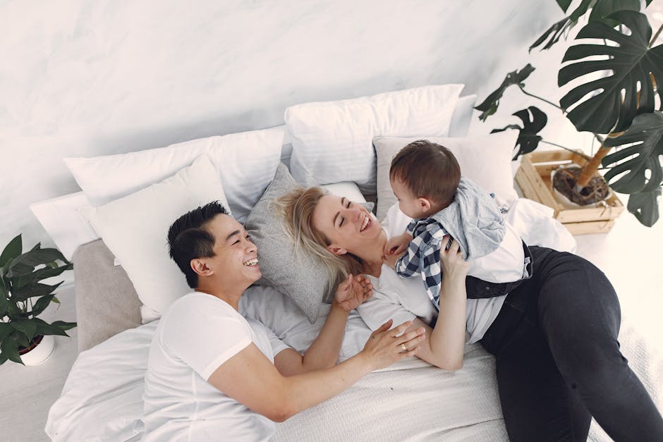 Family enjoying leisure time in a cozy, bright bedroom with indoor plants.