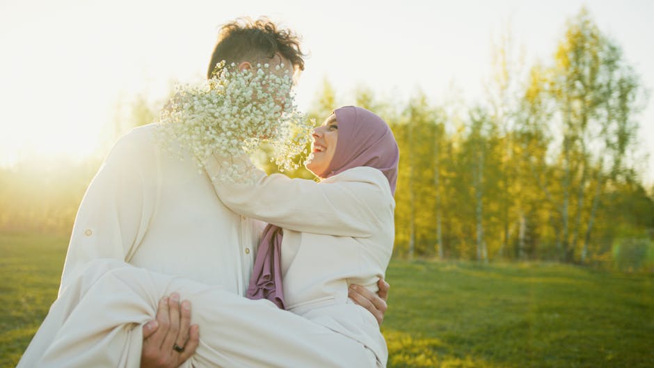 A couple joyfully embracing in a sunlit park, exuding happiness and love.