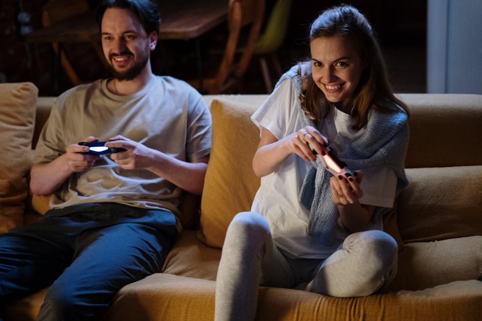 A happy couple plays video games on the sofa during a cozy evening at home.