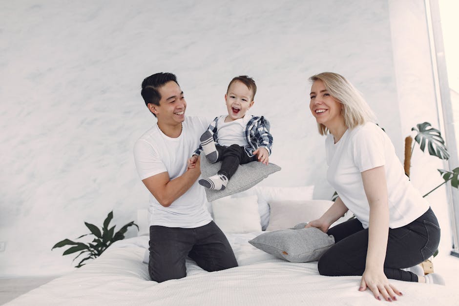 Lively family enjoying playful moments together on a cozy bed at home.