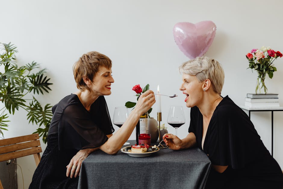 A loving LGBT couple enjoys a romantic dinner with wine and candles indoors.