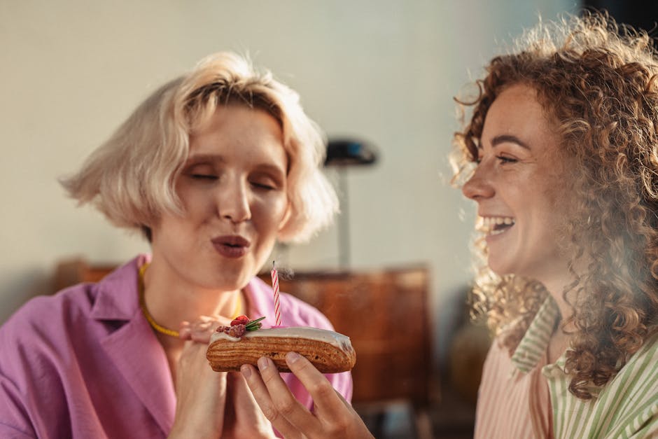 A joyful couple celebrating with an eclair topped with a lit candle.