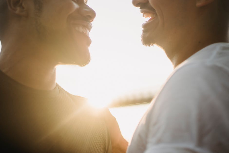 A joyful couple sharing a heartfelt laugh together in bright sunlight.