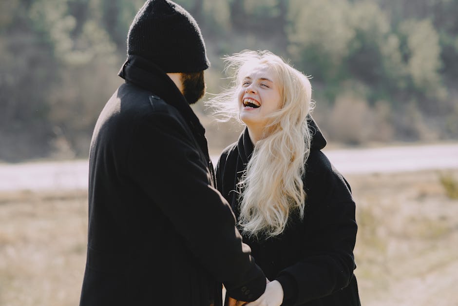 A joyful couple laughing together outdoors, capturing warmth and affection.