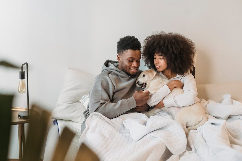 African American couple enjoying a cozy moment with their pet dog indoors, exuding warmth and happiness.