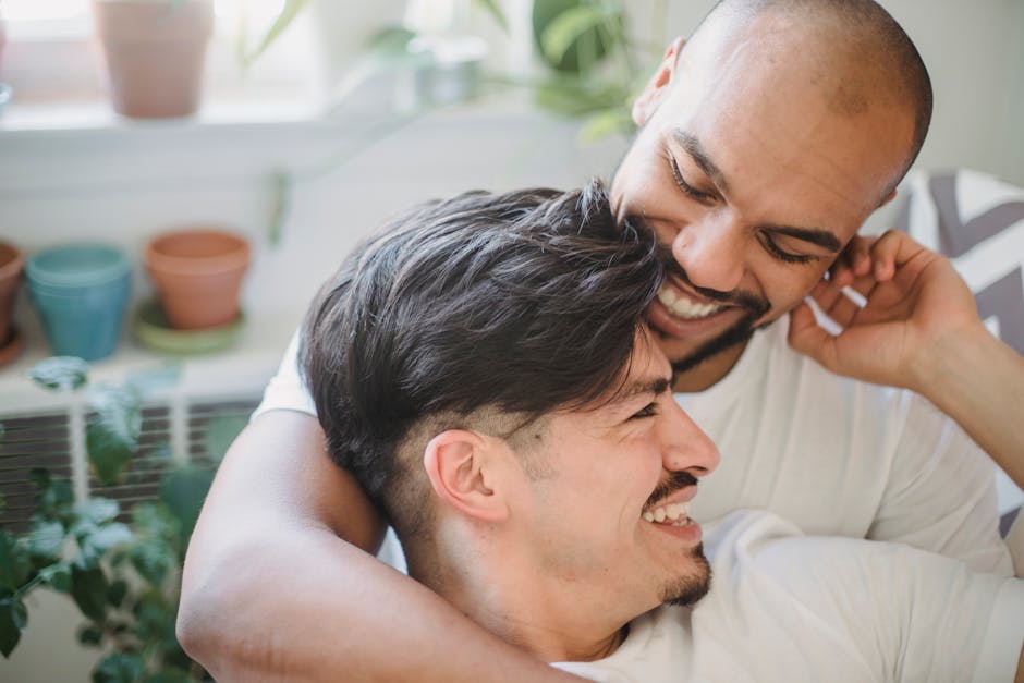 Happy couple embracing and laughing in a bright indoor setting, showcasing love and connection.