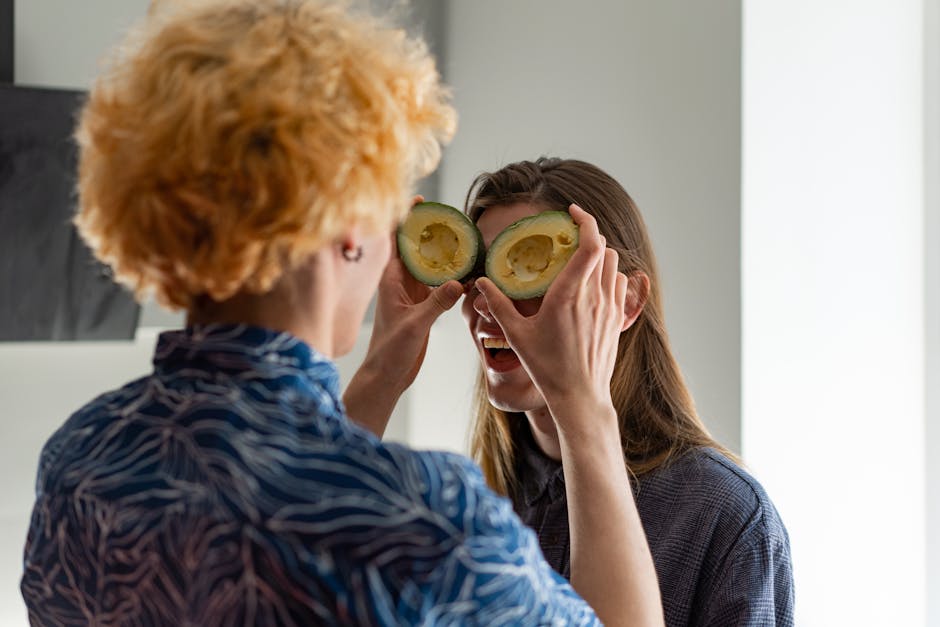 Fun moment with a couple using avocados as eyeglasses indoors.