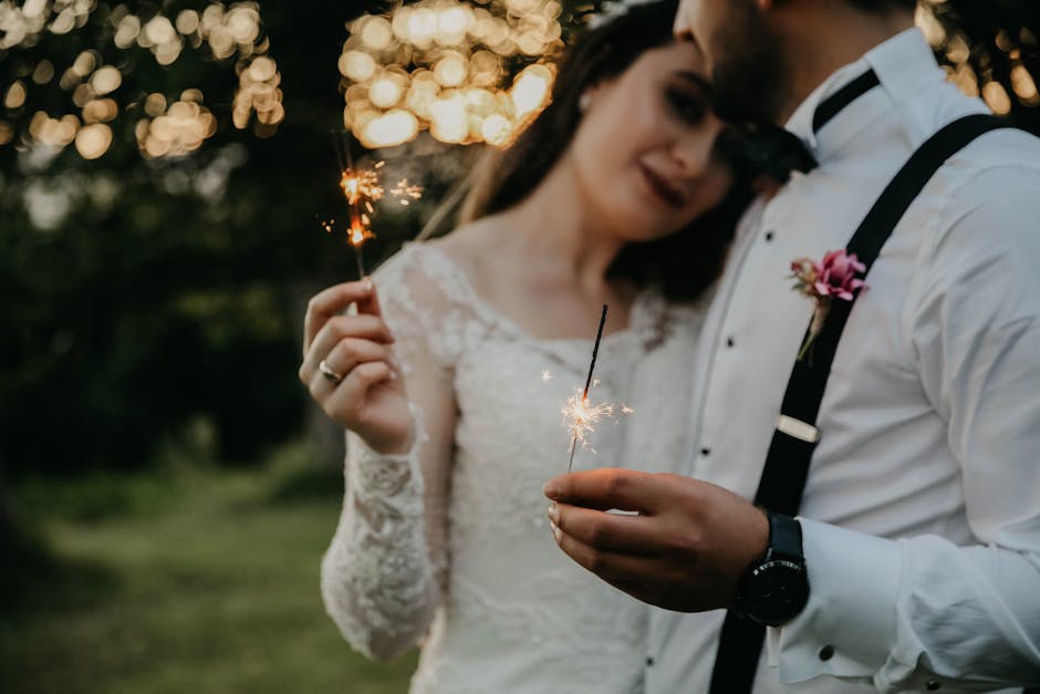 Couple celebrating their wedding outdoors with sparklers, creating a romantic scene.