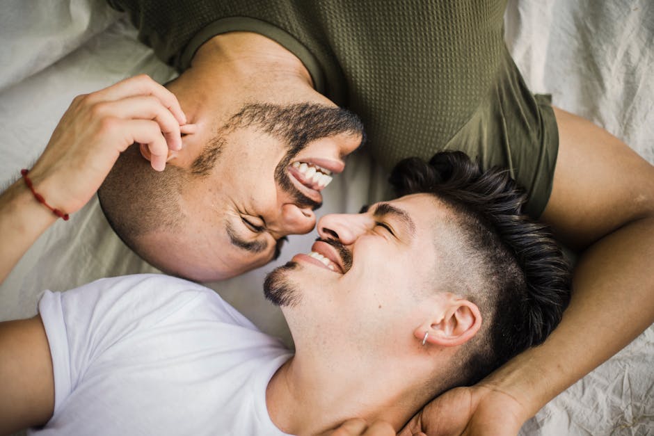 Close-up of a smiling couple lying face-to-face, expressing love and happiness.